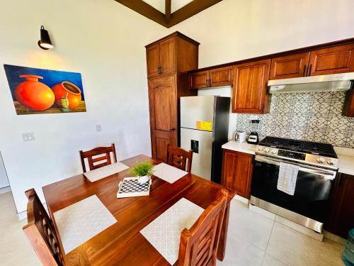 a kitchen with a wooden table and a stove and refrigerator at T4 - 2BR Eco Tiny Home Near the Beach by Veritas Pacifica in San Diego