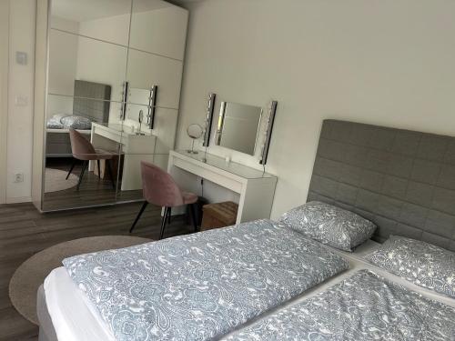 a bedroom with a bed and a desk and mirrors at Villa Åstorp in Åstorp