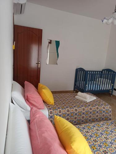 a living room with a white couch with colorful pillows at La Casa Sicula in Capri Leone
