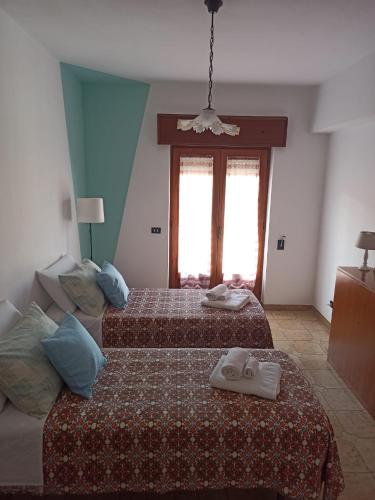 a bedroom with two beds and a couch at La Casa Sicula in Capri Leone