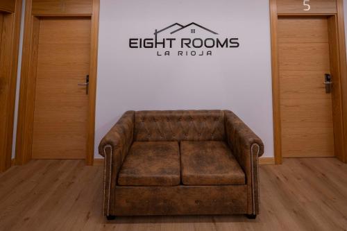 a brown couch sitting in a room with a sign at EightRooms La Rioja Pension in Logroño