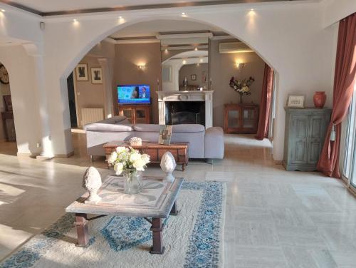 een woonkamer met een bank en een tafel bij Villa HELIOS in Cannes