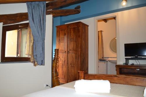 a bedroom with a bed and a window and a tv at Zest House in Santa Venerina