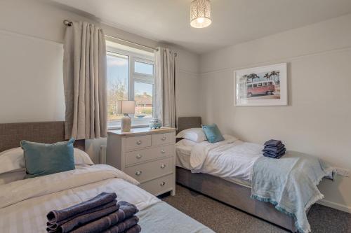 ein Schlafzimmer mit zwei Betten und einem Fenster in der Unterkunft 4 bedroom Pitchford in Earlham