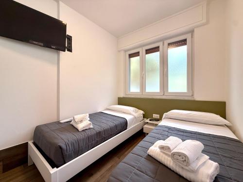 a bedroom with two beds and a tv on the wall at A 2 passi dal centro in Matera