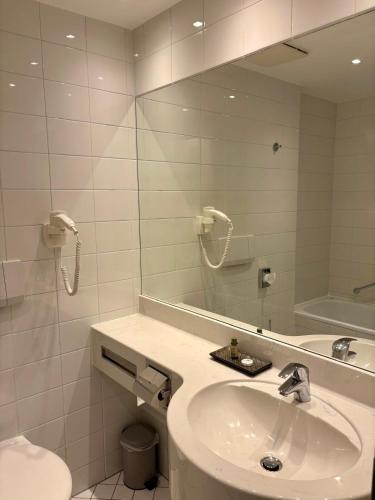 a bathroom with a sink and a toilet and a mirror at Hotel Zum Pfalzgrafen in Heidelberg