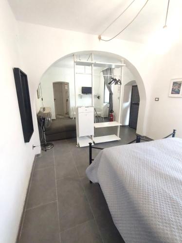 ein weißes Zimmer mit einem Bett und einem Spiegel in der Unterkunft Appartamento dei limoni in La Spezia