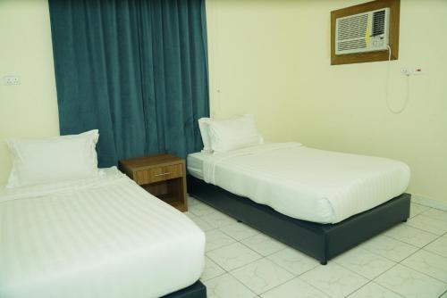 two beds sitting next to each other in a room at شقق رايف الزهور in Dammam