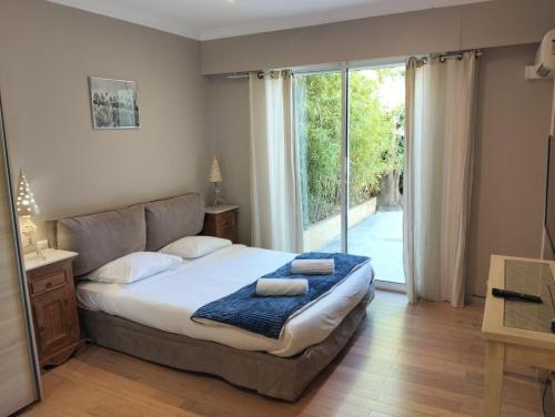 een slaapkamer met een bed en een glazen schuifdeur bij Villa HELIOS in Cannes
