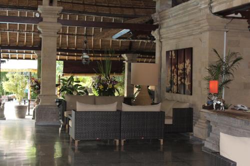 a living room with a couch and some plants at Bali Agung Village - CHSE Certified in Seminyak