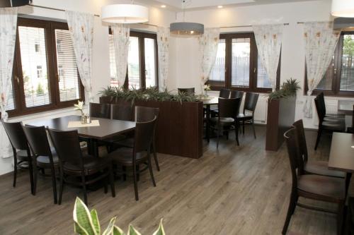 a dining room with tables and chairs and windows at Penzion Aladdin in Teplice