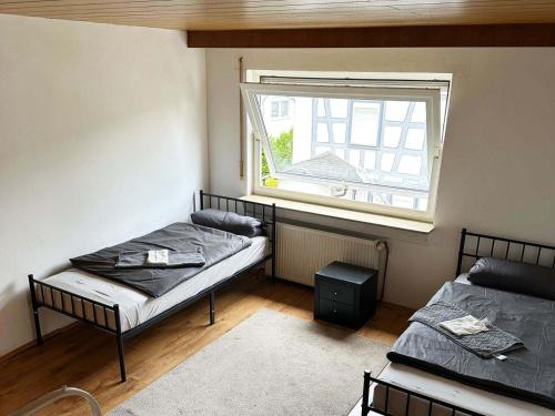 zwei Betten in einem Zimmer mit Fenster in der Unterkunft Stay & Relax Apartment in Flörsheim am Main in Flörsheim