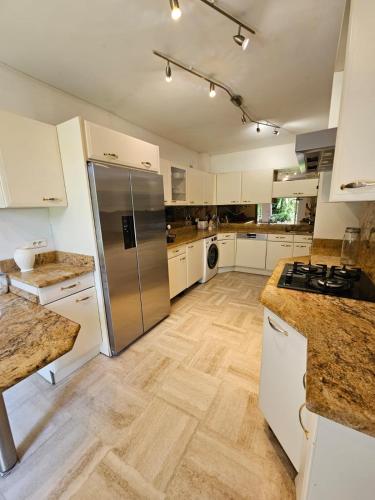 une cuisine avec des armoires blanches et un réfrigérateur en acier inoxydable dans l'établissement Villa HELIOS, à Cannes