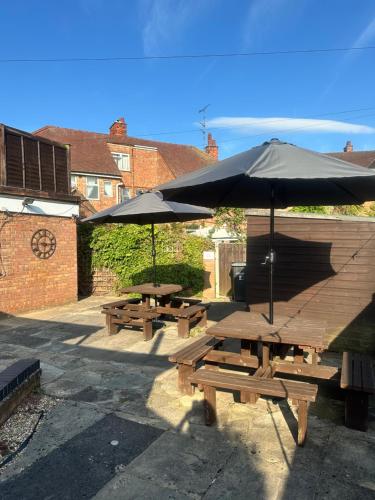 two picnic tables with umbrellas on a patio at Clarendon Lodge - accommodation only in Skegness