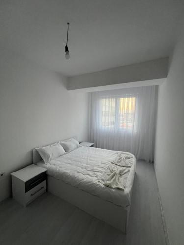 スコピエにあるStone Bazaar Apartments 2のベッドと窓のある白い寝室