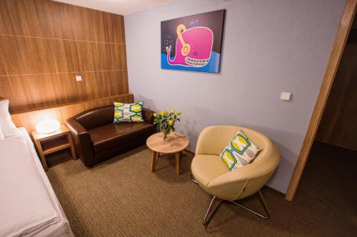 a room with a bed and a chair and a couch at Hotel Na Šustně in Krupá