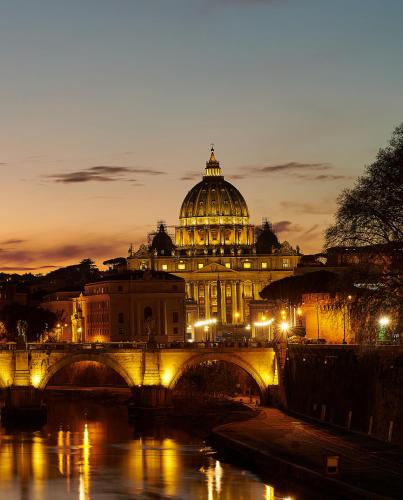 a view of a building with a bridge over a river at Vatican luxury - private parking free - meospiti luxury in Rome