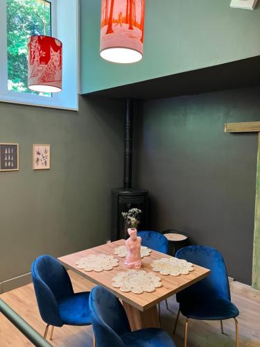 a dining room with a table and blue chairs at Le printemps, gîte nature in Bruyères