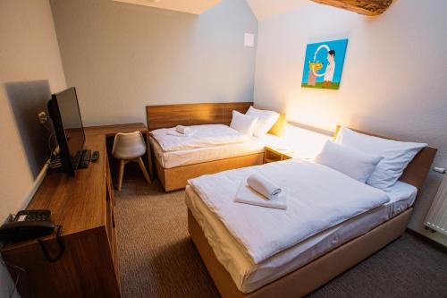 a hotel room with two beds and a television at Hotel Na Šustně in Krupá