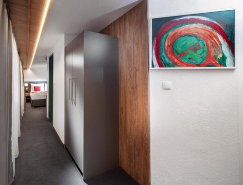 a hallway with a metal door and a painting on the wall at Hotel Höhlenstein in Tux