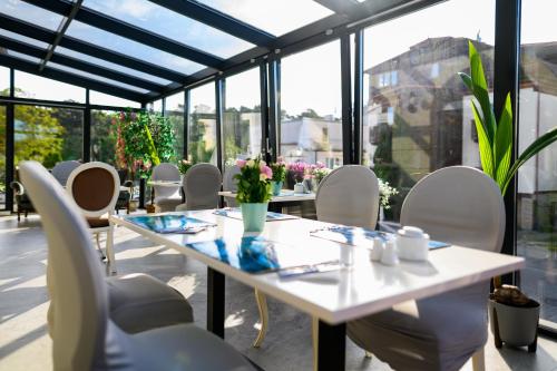 a table and chairs in a room with windows at Moris Beach Hotel in Gdańsk