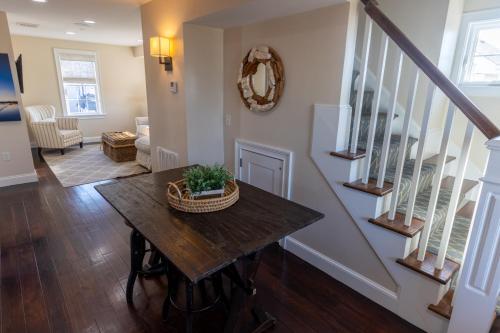 a living room with a table and stairs at The Newport Lofts - 617 Thames Street in Newport