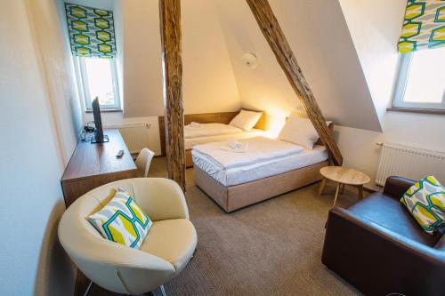 a small room with a bed and a chair at Hotel Na Šustně in Krupá