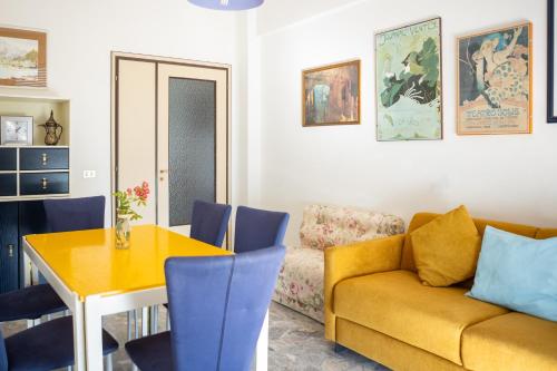 a living room with a yellow couch and a table at Frontemare - Casa Casoni in Marcelli