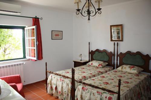 1 dormitorio con 2 camas y ventana en Quinta do Cerquito, en Ferreira do Zêzere