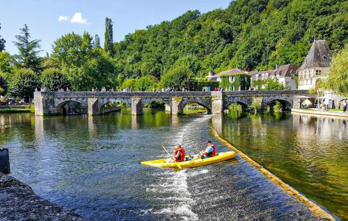 zwei Personen sind in einem gelben Boot auf einem Fluss in der Unterkunft Charmante Maison À La Campagne in Bourg-du-Bost