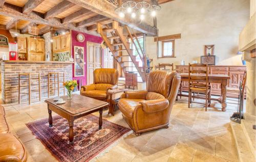 - un salon avec des fauteuils en cuir et une table dans l'établissement Charmante Maison Avec Piscine, à Archignac