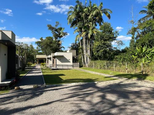 a house on the side of a road with palm trees at Vila do Porto Pousada in Morretes