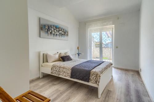 a white bedroom with a bed and a window at VILA SENTIO MARE-Apartments Livaić Željko in Pirovac