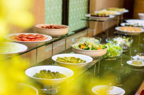 a buffet with plates of food on a glass table at Muong Thanh Holiday Vung Tau Hotel in Vung Tau