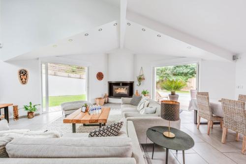 Elle comprend un salon doté d'un mobilier blanc et d'une cheminée. dans l'établissement Villa Djun Hossegor 4 étoiles, piscine, 12 personnes, à Soorts-Hossegor