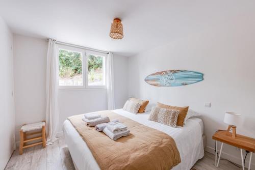 une chambre blanche avec un lit avec des serviettes dessus dans l'établissement Villa Djun Hossegor 4 étoiles, piscine, 12 personnes, à Soorts-Hossegor