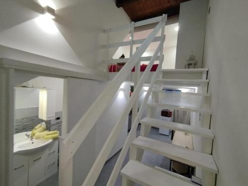 a white staircase in a bathroom with a sink at The Cordari House in Siracusa