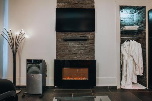 a living room with a fireplace and a tv at Le Love Spa in Lyon