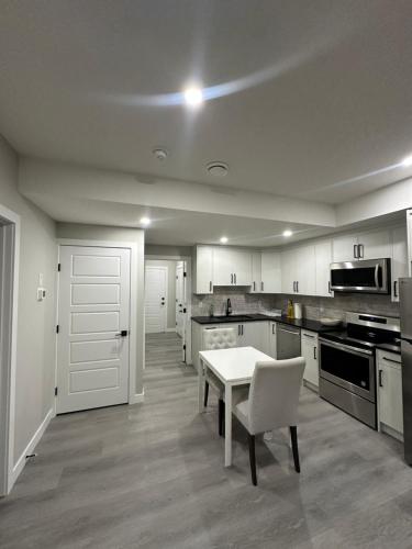 a kitchen with a white table and a white chair at Beautiful 2 bedroom 2 bath in NW Calgary in Calgary