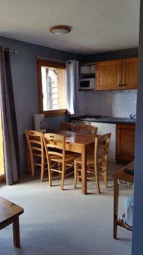 une cuisine avec une table et des chaises en bois dans l'établissement Appartement confortable à Dévoluy, vue sur les montagnes, à Superdevoluy