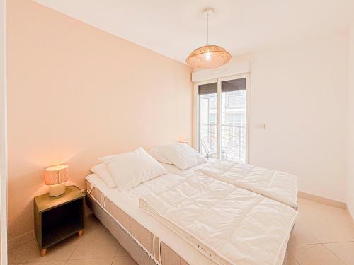 une chambre blanche avec un lit et une fenêtre dans l'établissement Espace détente en centre ville - Parking, AC, wifi, à La Celle-sous-Gouzon