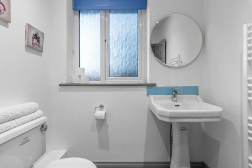 a white bathroom with a sink and a mirror at 7 Bed House Pitchford Road in Earlham