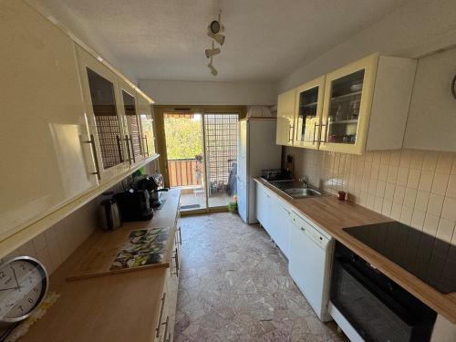 une cuisine avec des placards blancs et une horloge sur le comptoir dans l'établissement The holidays that smells of Summer, à Sainte-Maxime