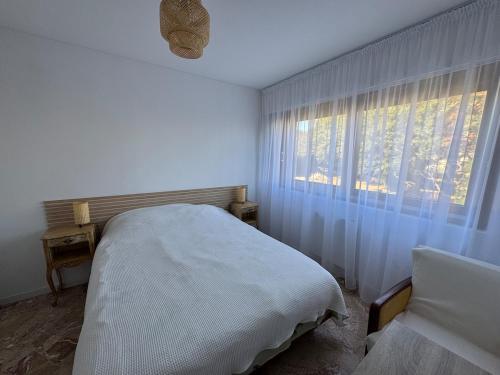 une chambre blanche avec un lit et une fenêtre dans l'établissement The holidays that smells of Summer, à Sainte-Maxime