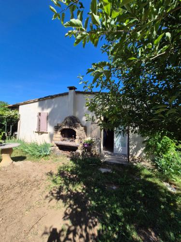 une maison avec un four en briques dans la cour dans l'établissement Charmant petit Mazet au cœur d'un magnifique jardin et d'une grande piscine à Uzès, à Uzès