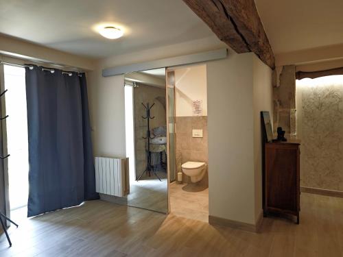 La salle de bains est pourvue de toilettes et d'une porte en verre. dans l'établissement Gîtes des cerisiers, à La Celle-sous-Gouzon