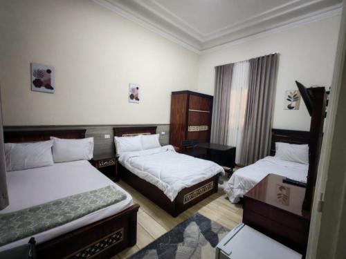 a hotel room with two beds and a window at Centro Citta Hotel in Cairo