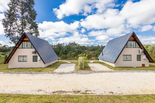 two houses with metal roofs on a field at Villa Estoril in Campina Grande do Sul
