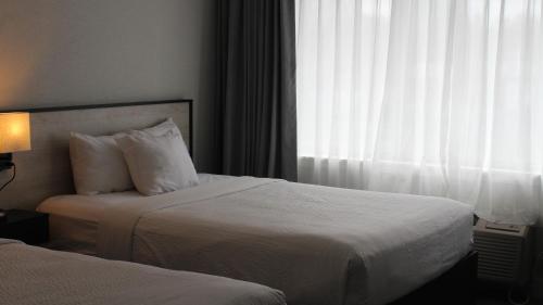a hotel room with two beds and a window at Ramada Plaza by Wyndham Montreal in Montréal