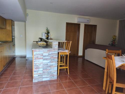 a kitchen with a counter and a table in a room at Casa da Tia Bina in Castelo de Paiva